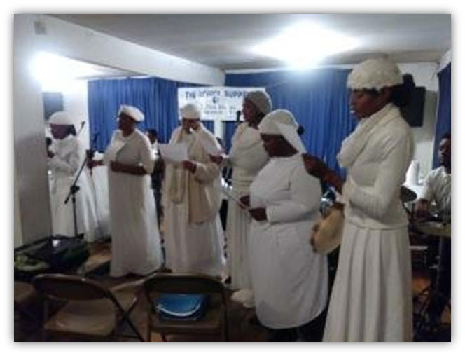 The Sisters In Christ is praising the Lord at the Communion and Feet Washing Service.   They are singing the song, Hold to Gods Unchanging Hand. 